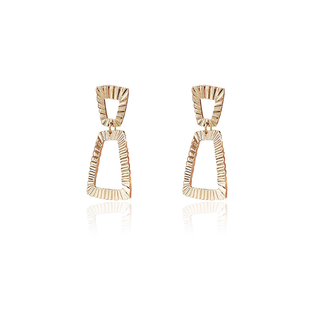 Detailed view of the gold trapezoidal textured earrings