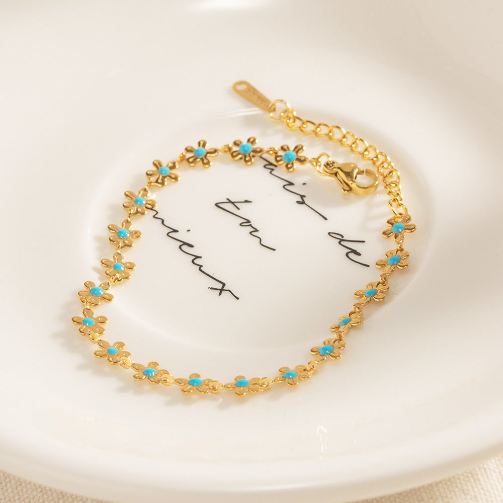 Close-up of the blue enamel flower detail on the stainless steel bracelet