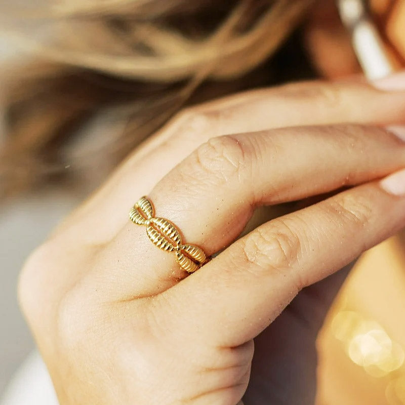 A woman wearing the adjustable gold cowrie shell ring to show the fit and style.