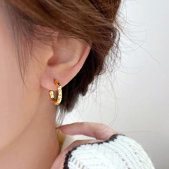 Model showcasing the gold twisted knot C-shape earring