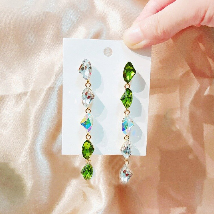 Detailed view of the green and clear teardrop gemstones