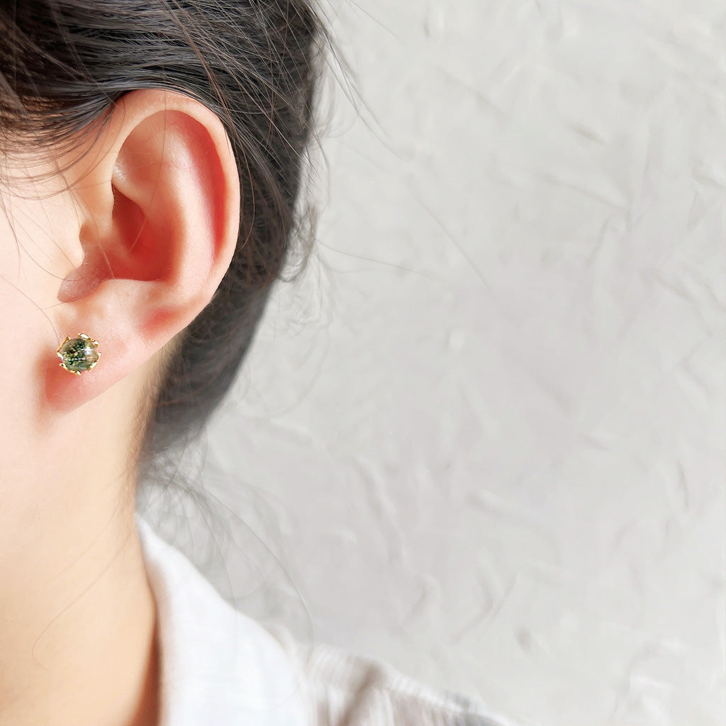 A model wearing the green shimmer stone stud earring for a chic look