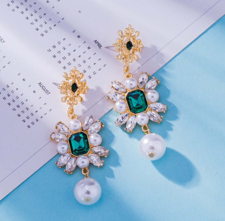 A detailed view of the emerald and pearl earrings craftsmanship