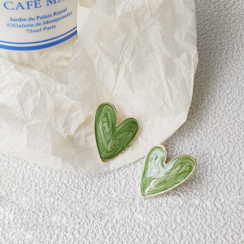 A pair of green and gold vintage heart-shaped enamel earrings.