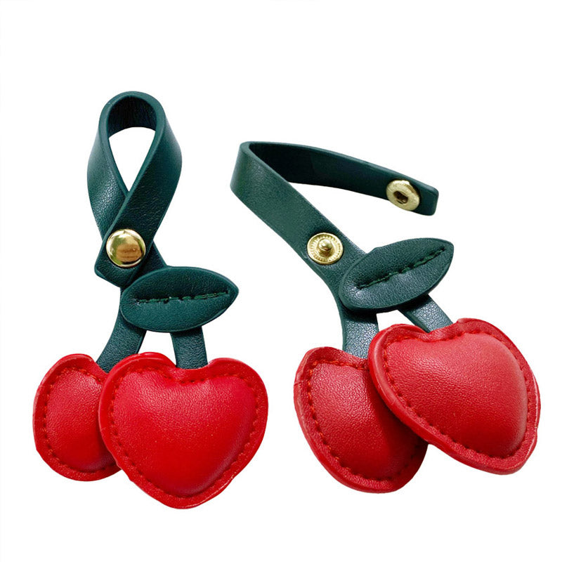 Detailed view of the red cherry PU leather charm with gold snap button