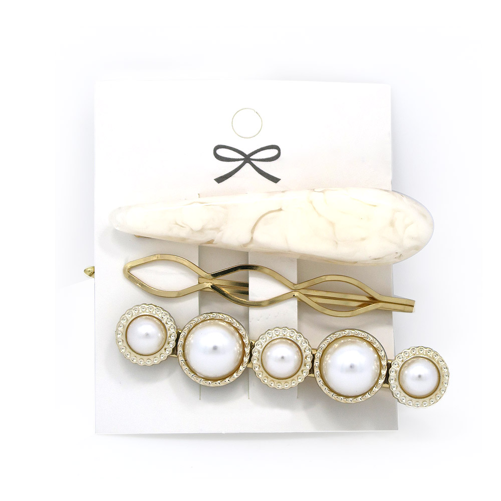 A versatile set of three gold and pearl hair clips for various styles