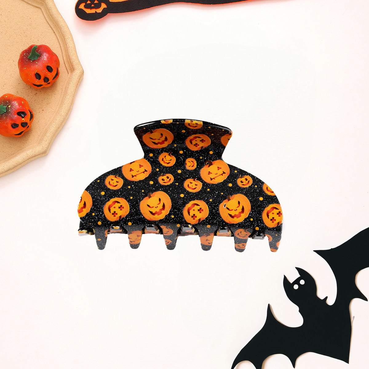 A detailed view of the orange pumpkin jack-o'-lantern hair clip