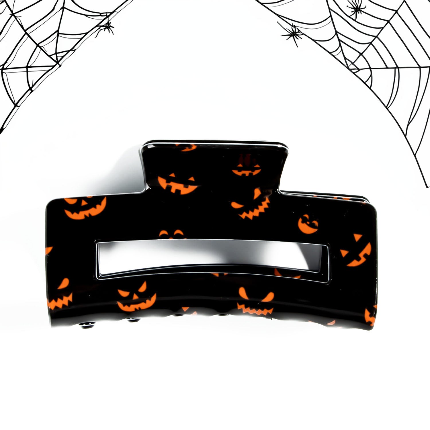 A woman demonstrating the use of a Halloween pumpkin claw clip in her hair.