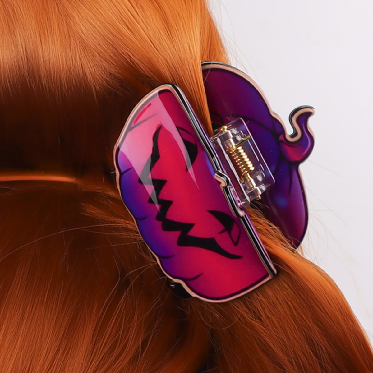 A woman wearing a fun jack-o'-lantern hair clip for a Halloween party.