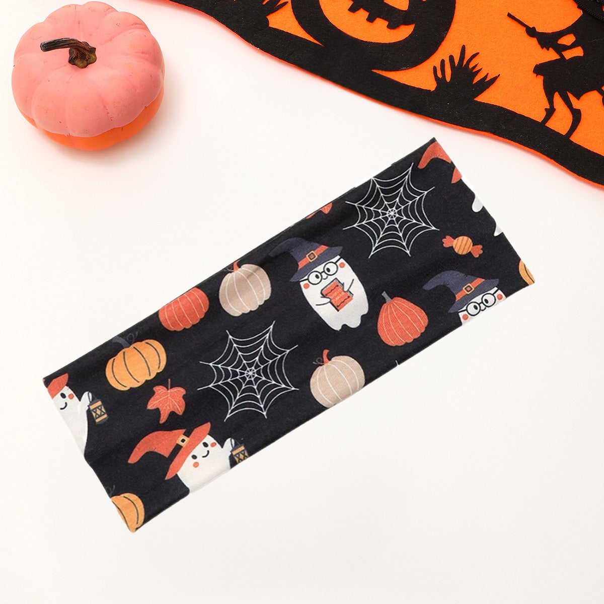 A close-up of the fabric pattern on a Halloween headband, featuring cute ghosts, candy, and spider webs.