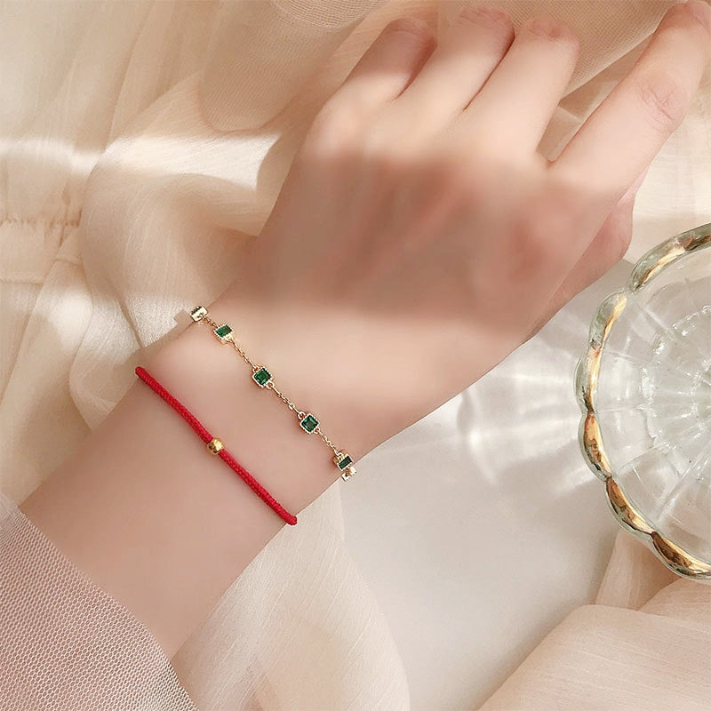 A model's hand showcasing the elegant 925 sterling silver bracelets with green crystals.