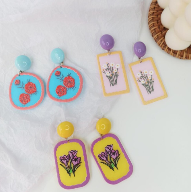Three pairs of handmade polymer clay earrings showcasing intricate floral designs