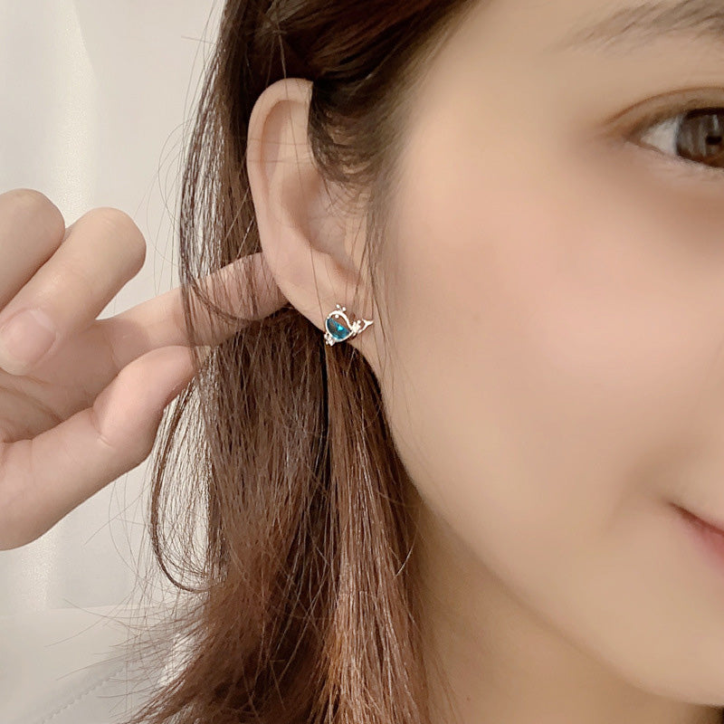Model wearing a blue gemstone huggie earring from the sea-themed collection