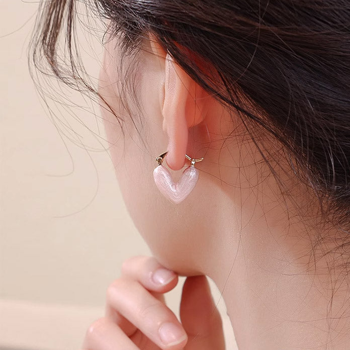 Close-up of the pink enamel heart hoop earring being worn