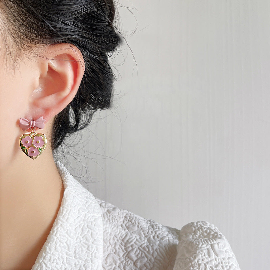 Detailed view of the enamel flower on the heart pendant earring