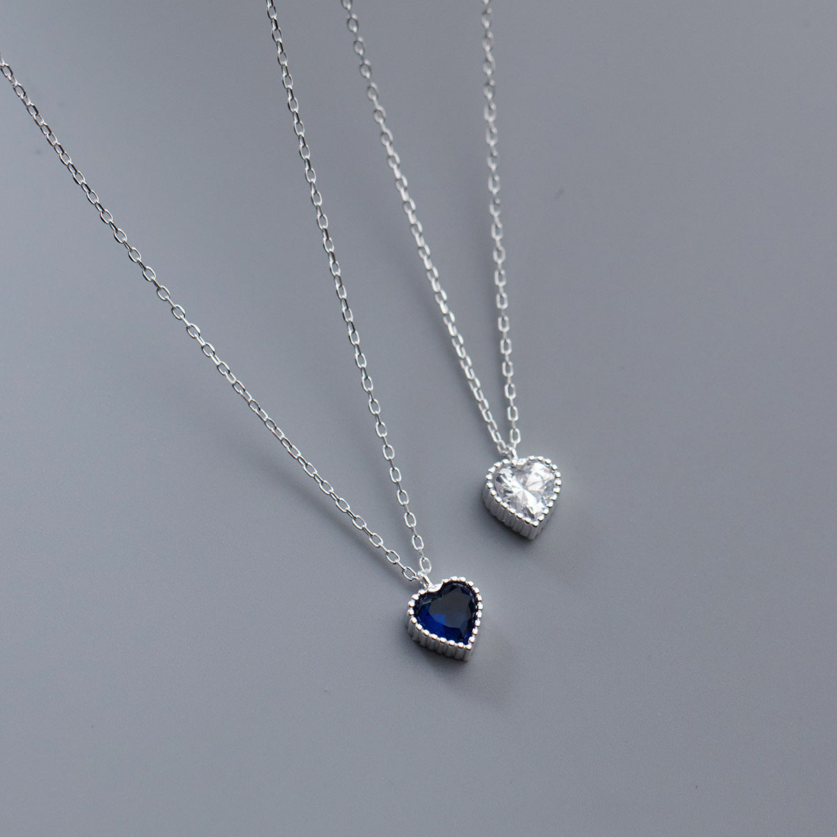 Detailed view of the blue and clear zircon heart pendants