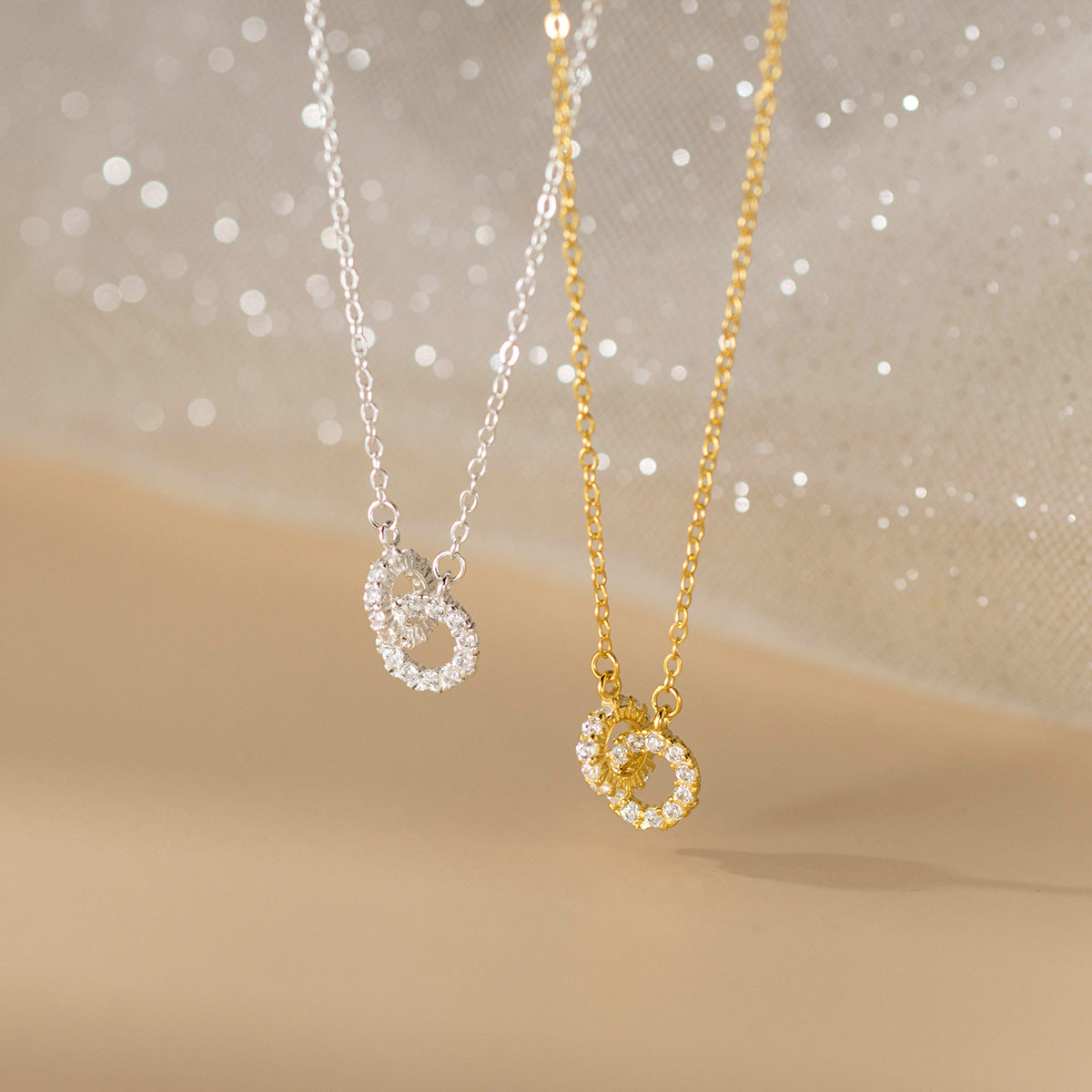 Silver and gold versions of the interlocking double ring necklace