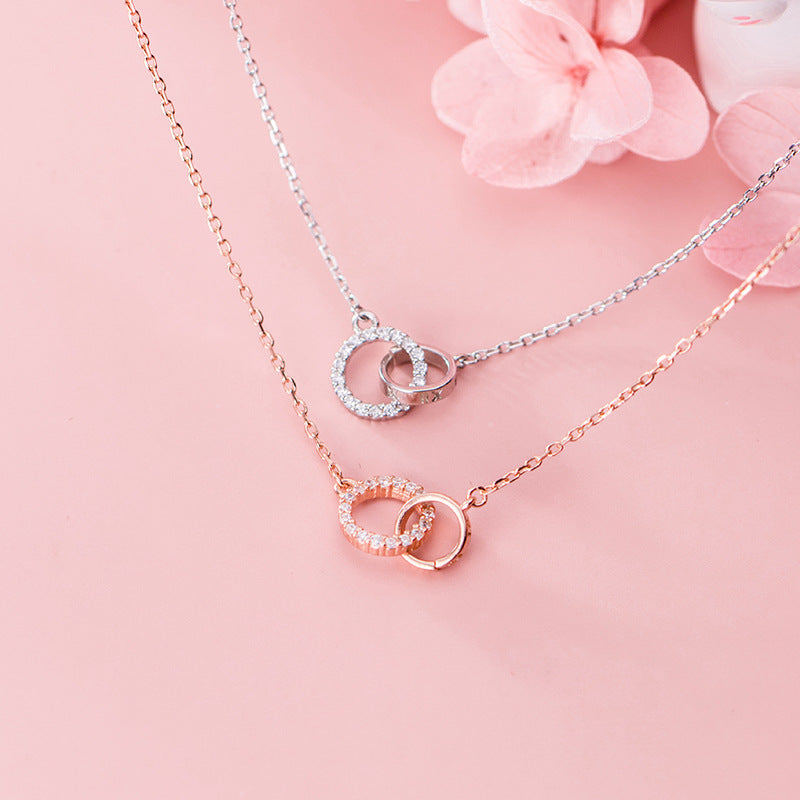 A stylish display of both the silver and rose gold interlocking circle necklaces.