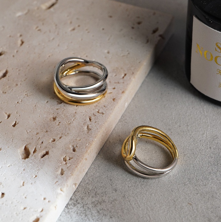 A pair of two-tone stainless steel rings showcasing the intertwined design