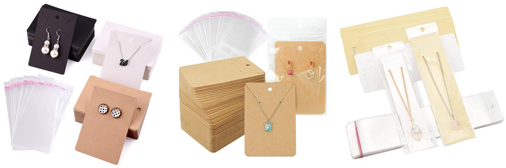 A collection of jewelry backing cards in various colors next to clear OPP bags.