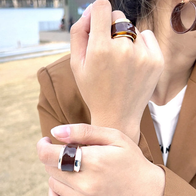 A collection of chocolate brown enamel rings and matching earrings