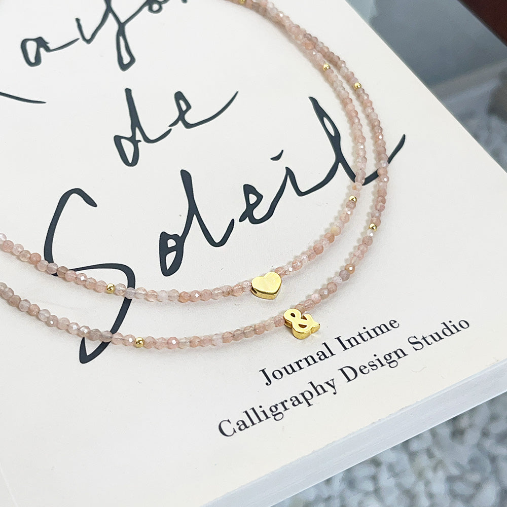 Lifestyle image of the pink beaded sterling silver heart necklace set being worn.