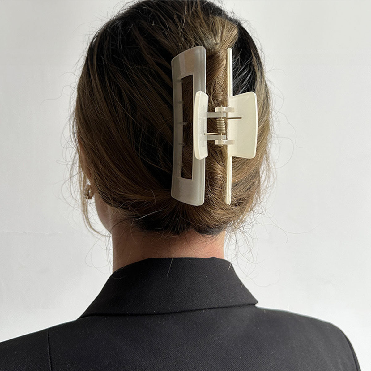 A large beige rectangle hair clip securing a hair bun, demonstrating its strong hold.