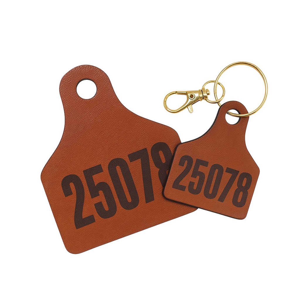 Detailed view of a custom leather cow tag keychain with numbering