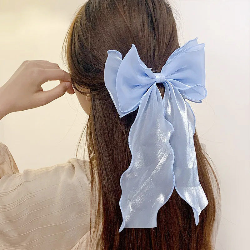 Model with brown hair wearing the light blue ribbon bow