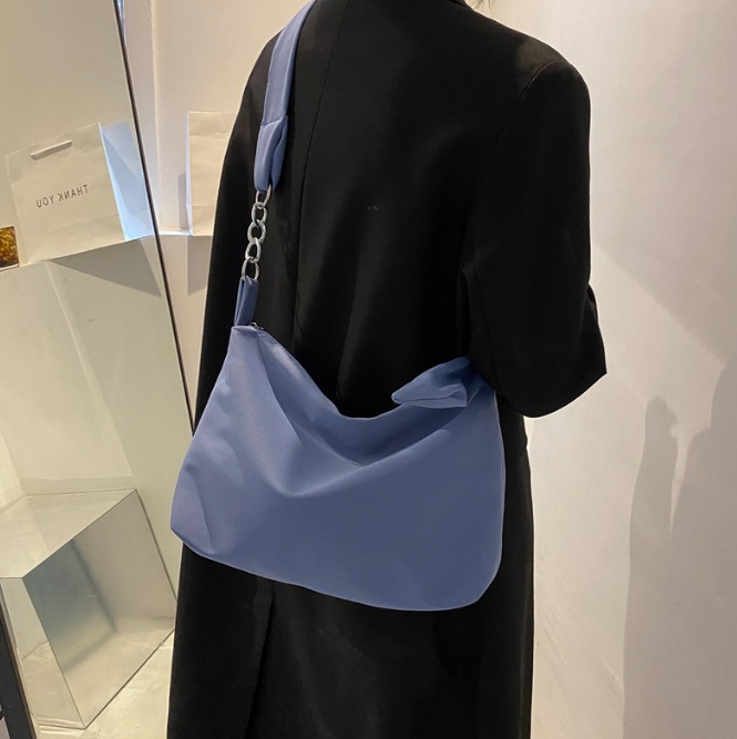 Model showcasing the light blue version of the cross-body sling bag.