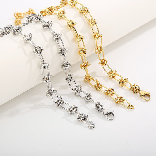 A selection of gold and silver stainless steel chain necklaces and bracelets with knot details