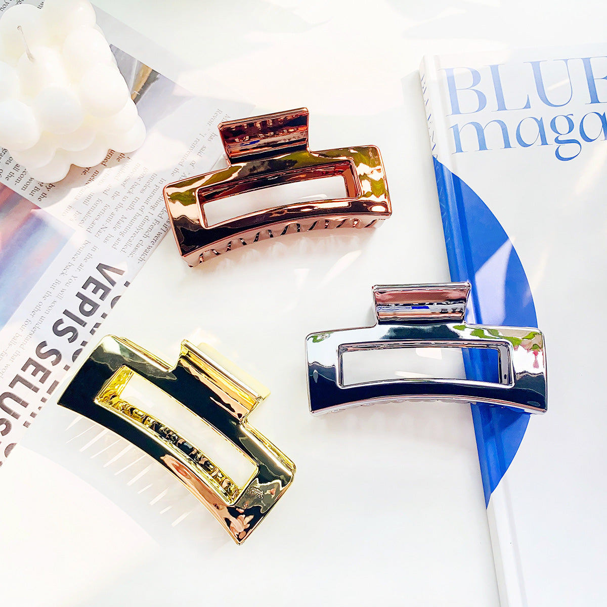 Three metallic hair clips in gold, silver, and gunmetal black finishes