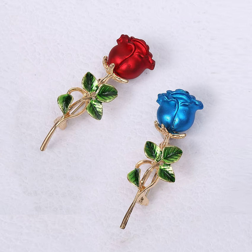 A close-up of the red and blue enamel rose brooches, showcasing the vibrant colors and detailed craftsmanship.