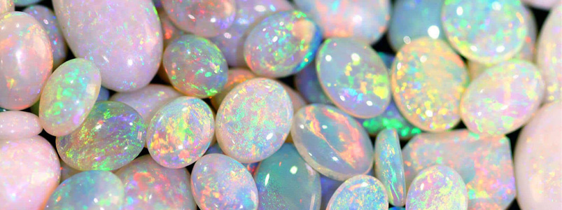 A close-up of iridescent opal gemstones, displaying their unique play-of-color for the October birthstone.
