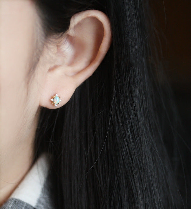 A model wearing the 925 silver gold oval opal stud earring.