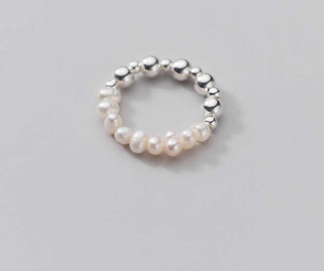A stylish pearl and silver bead elastic ring displayed on a surface