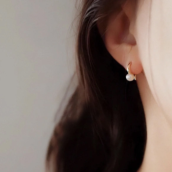 Close-up of the 925 sterling silver pearl hook earring being worn.
