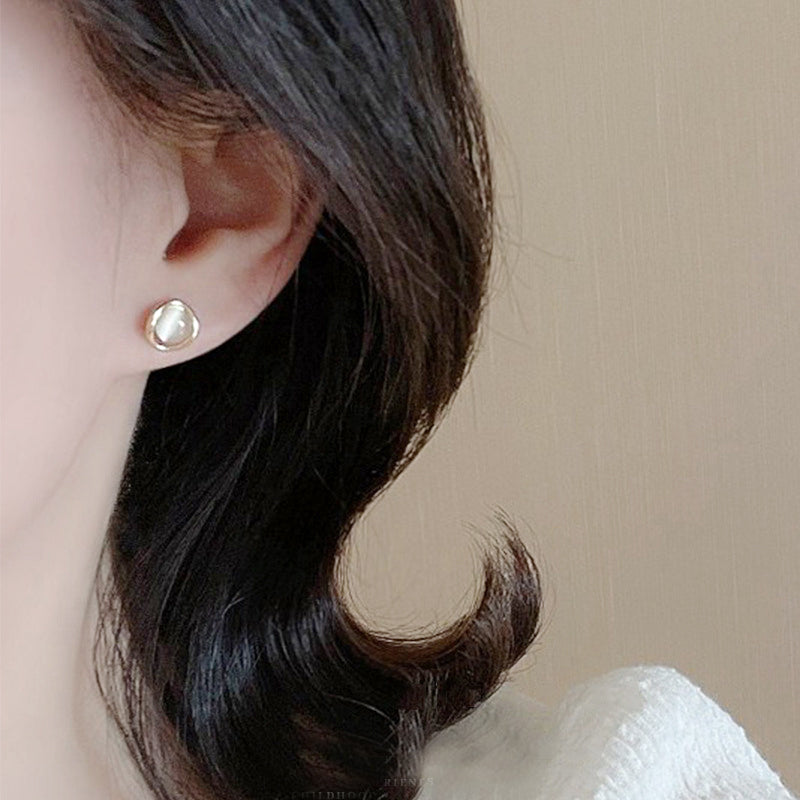 A model wearing the sterling silver cat-eye stud earring to show its scale and elegance.