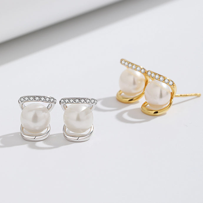 Multiple pairs of silver and gold pearl stud earrings displayed together