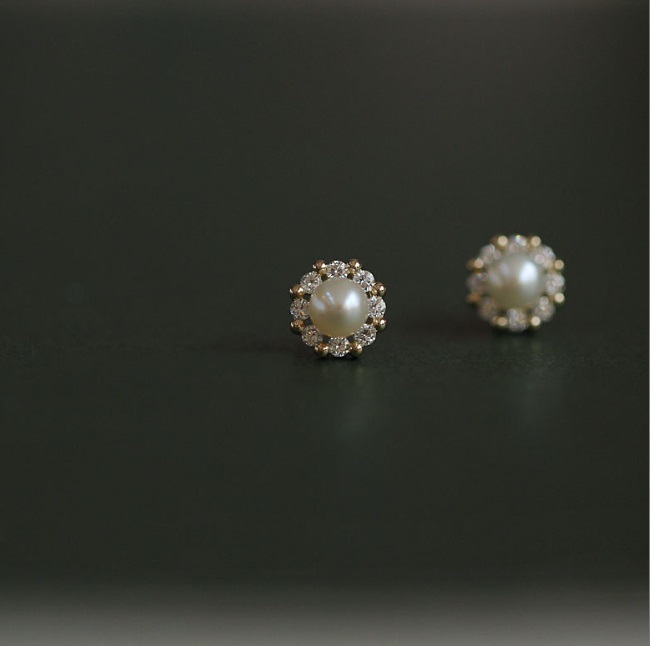 Close-up of pearl stud earrings with a halo of sparkling CZ stones
