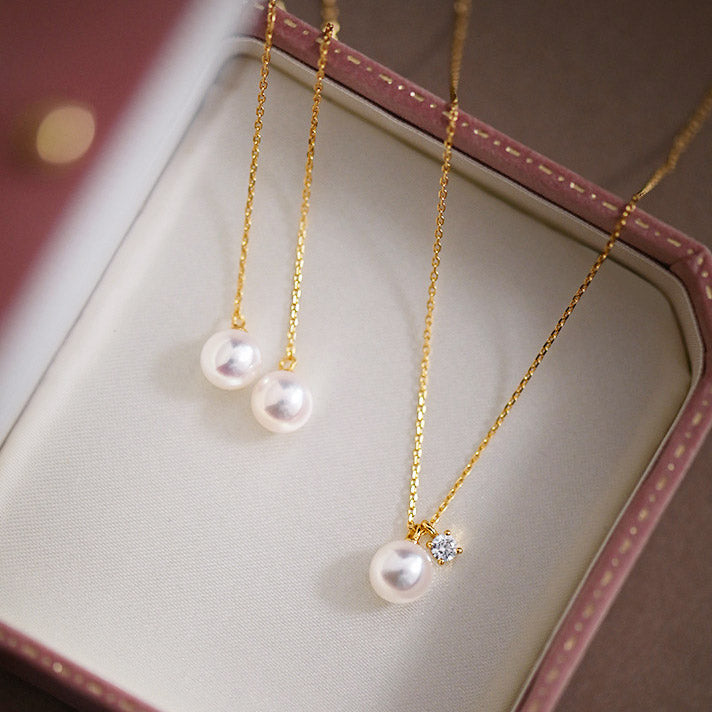 Both silver and gold finish pearl necklaces displayed in a box