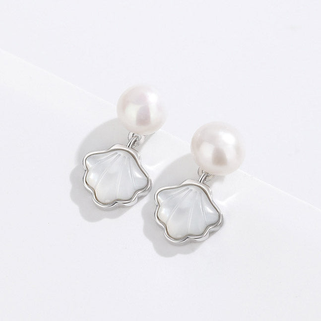 Detailed view of the fan-shaped shell and pearl earrings