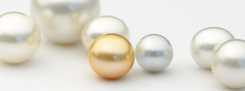 An elegant collection of white and golden pearls, the classic birthstone for June.