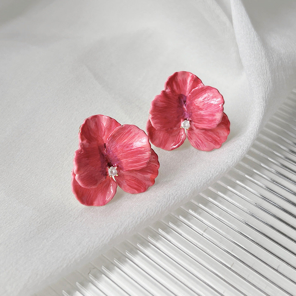 Detailed view of the 3D enamel flower earrings with zircon centers
