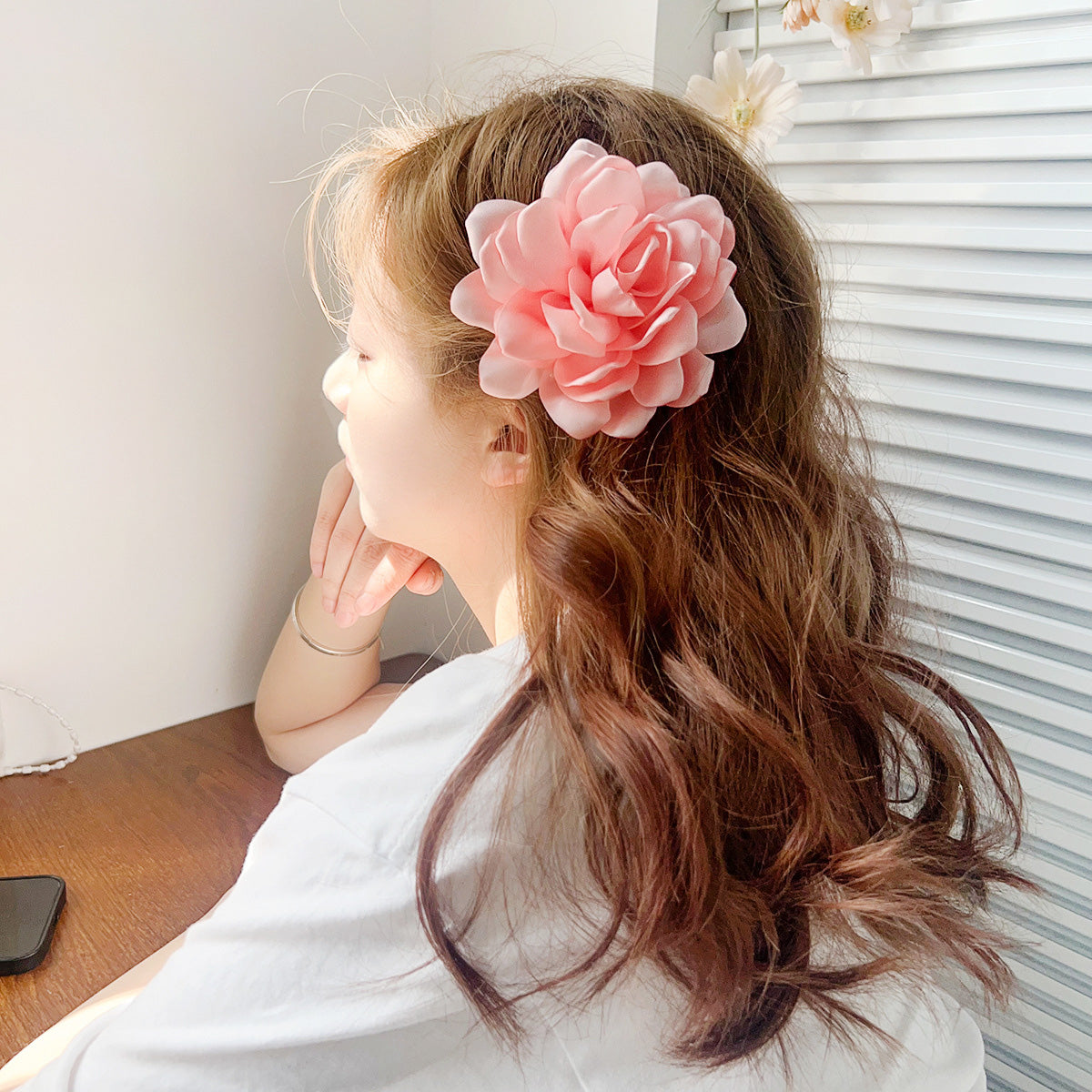 A model showcasing the large pink rose flower hair clip in her hair.