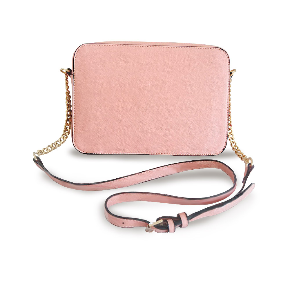 A pink leather crossbody bag with both gold chain and leather straps attached
