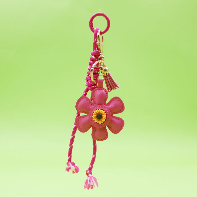 A close-up of the pink leather sunflower keychain with gold hardware