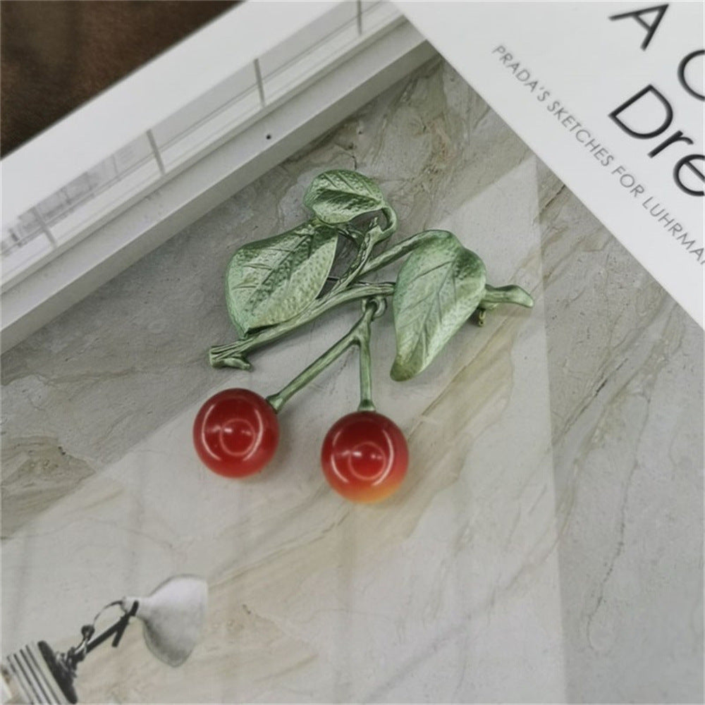 A stylish lifestyle shot of the Sweet Retro Cherry Brooch.