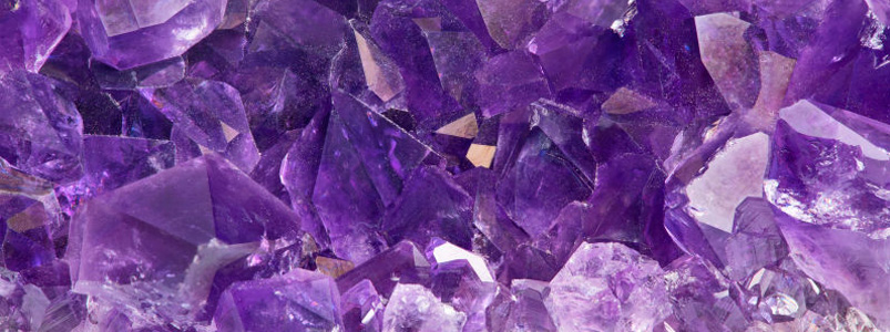 A close-up of vibrant purple amethyst crystals, the birthstone for February.