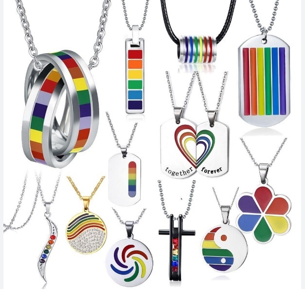A collection of various rainbow-themed LGBTQ+ pride jewelry including rings, bracelets, and necklaces.
